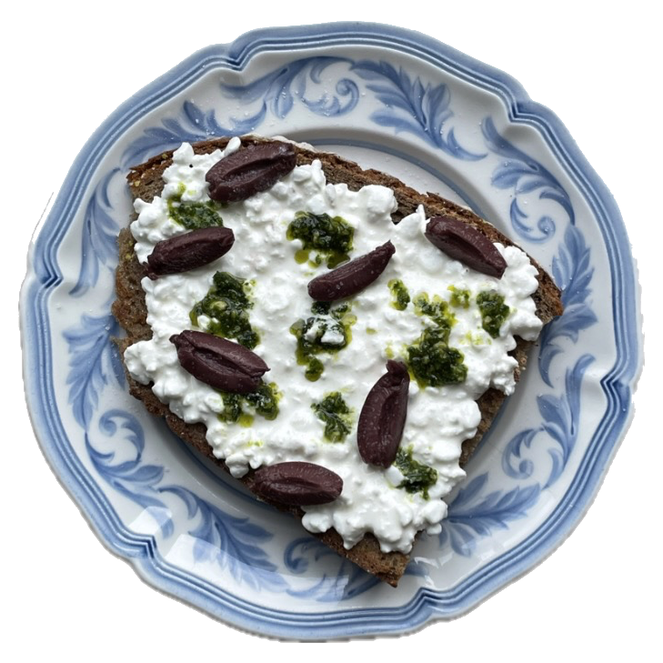 Cottage cheese toast with olives and pesto on a blue plate