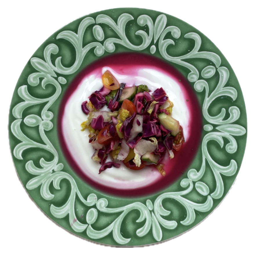 Salad with yogurt on a green scroll-rim plate