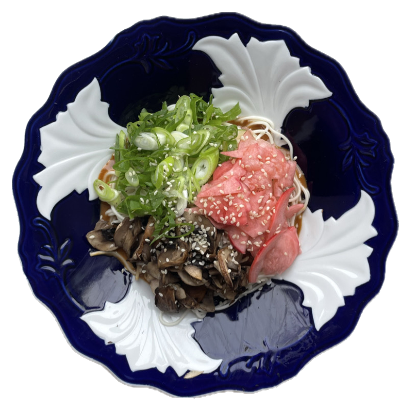 Noodles with mushrooms, scallion and pickled radish on a cobalt plate